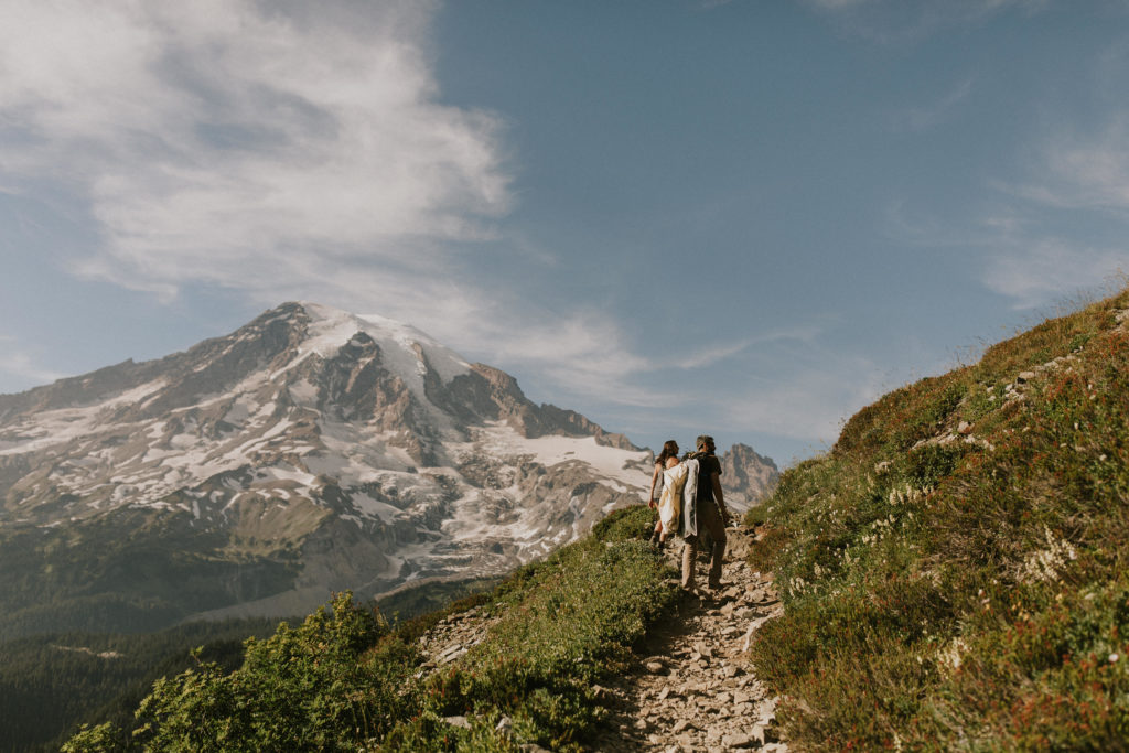 couple walking up mountain trail