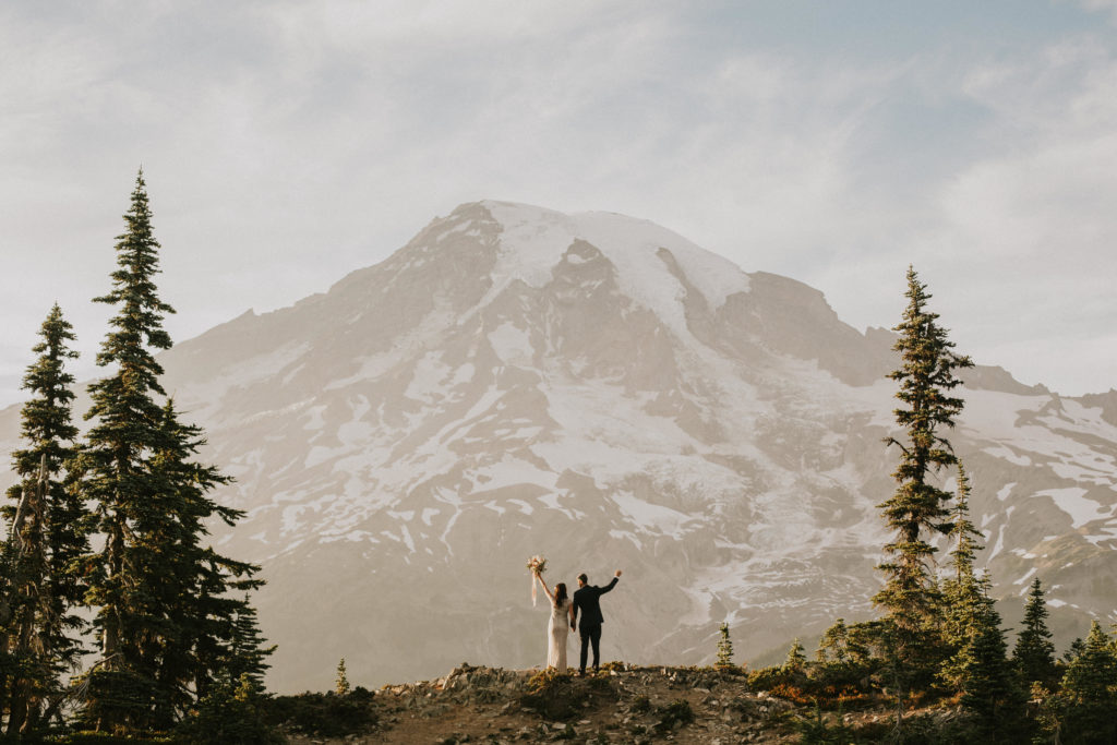 couple standing in front of mountain at mountain wedding
